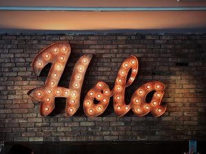 a lit up sign that says "Hola"